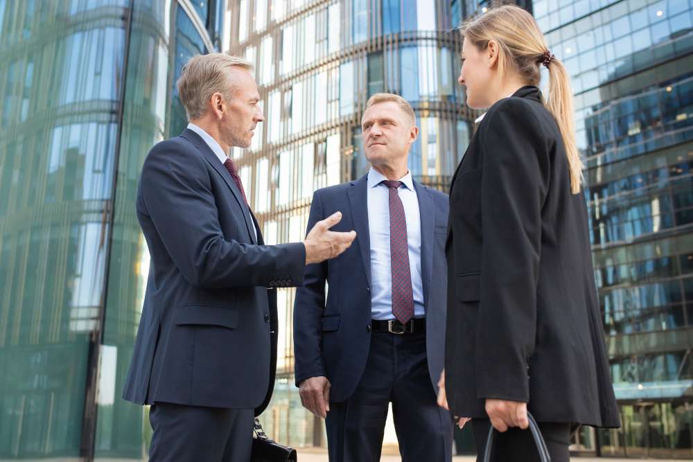 team-business-people-meeting-city-standing-talking-office-buildings-discussing-contract-low-angle-shot